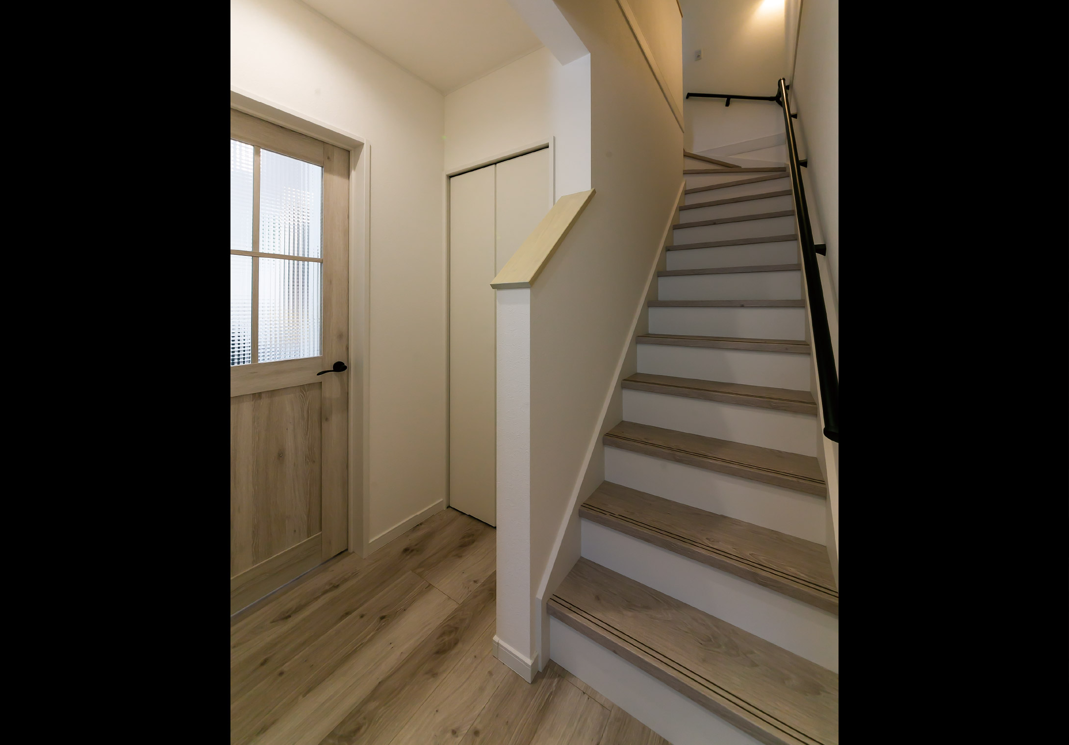 白い壁と木目が調和するホールと階段