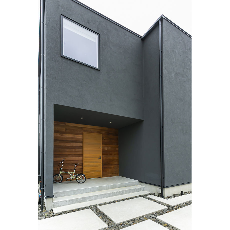 玄関まわりは木の素材感を生かしたデザインに。黒一色の外観のアクセントになっている